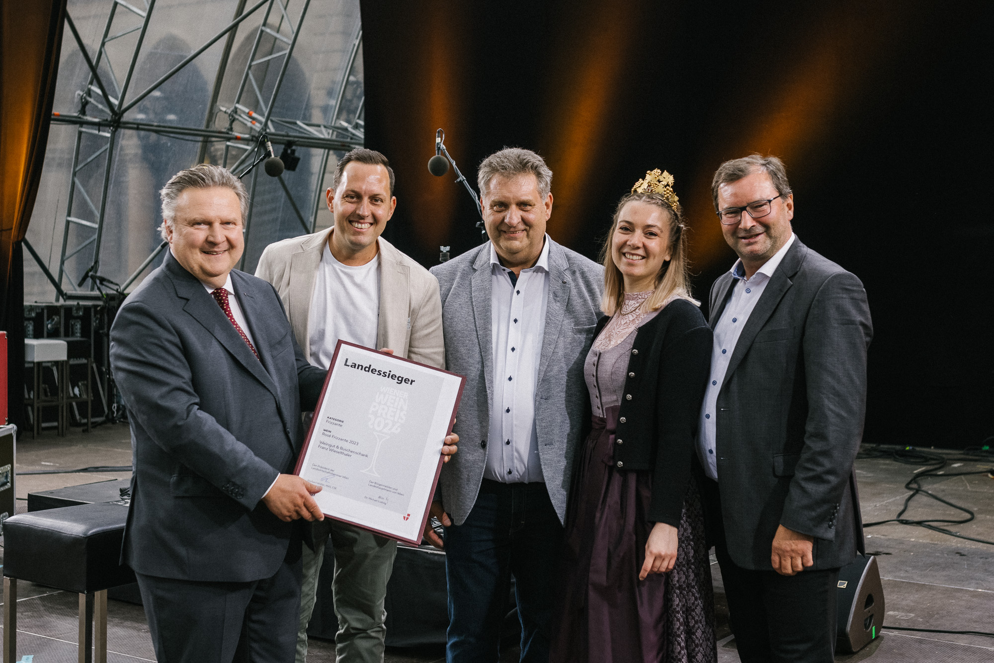 Bürgermeister Michael Ludwig, die Weinprinzessin 2024 und drei weitere Personen mit einer Urkunde in der Hand beim Wiener Weinpreis 2024.