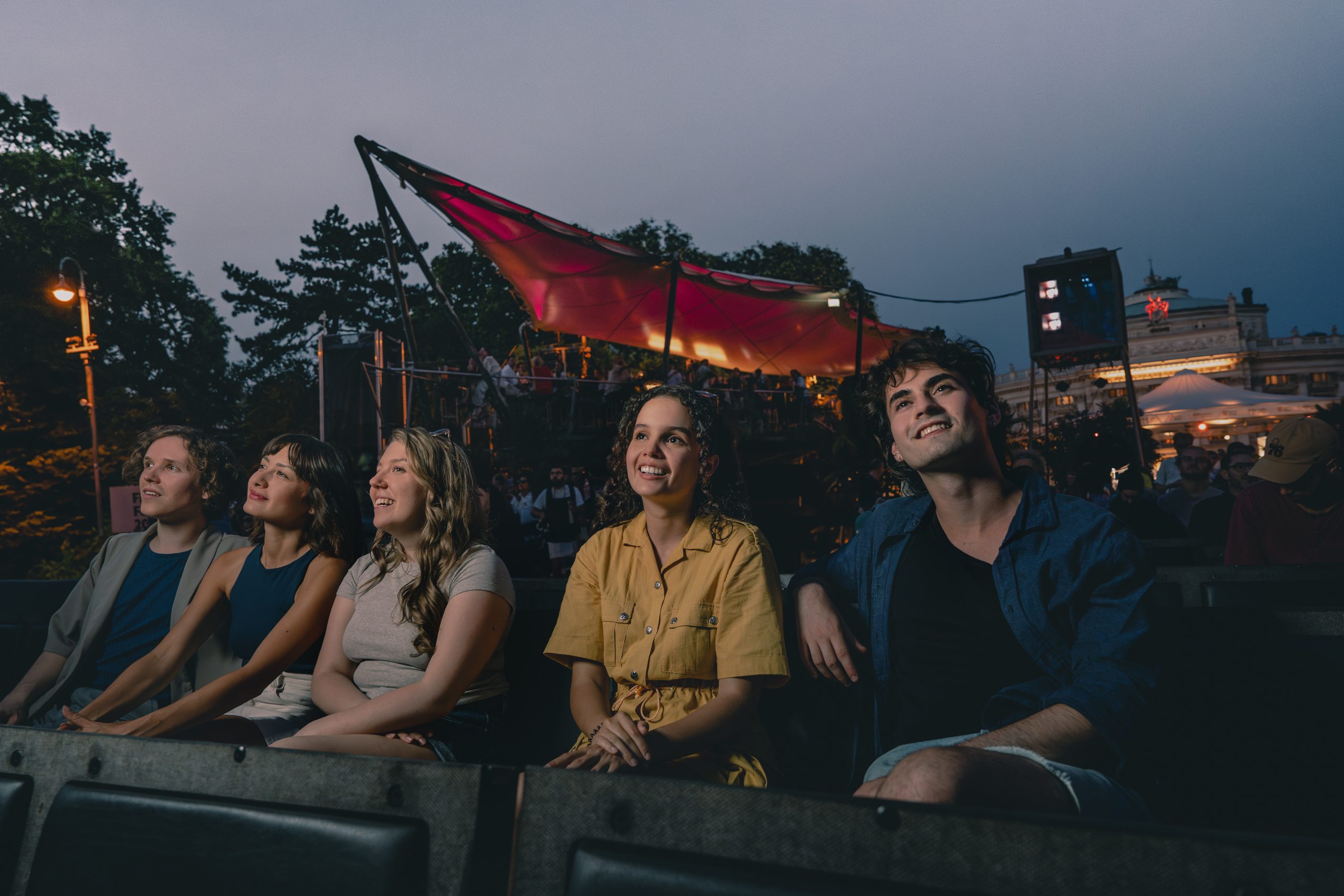 Frontale Ansicht von Freund*innen, die auf die Leinwand vor ihnen schauen.