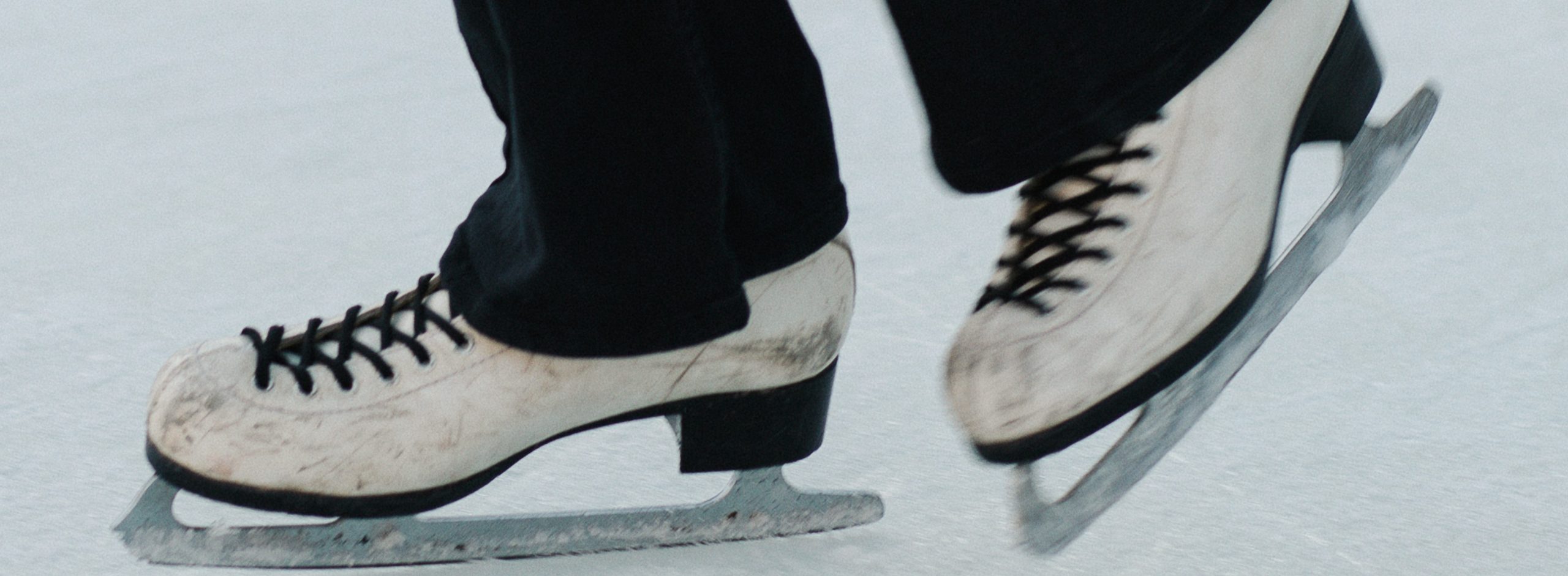 Nahaufnahme von Schlittschuhen am Eis.