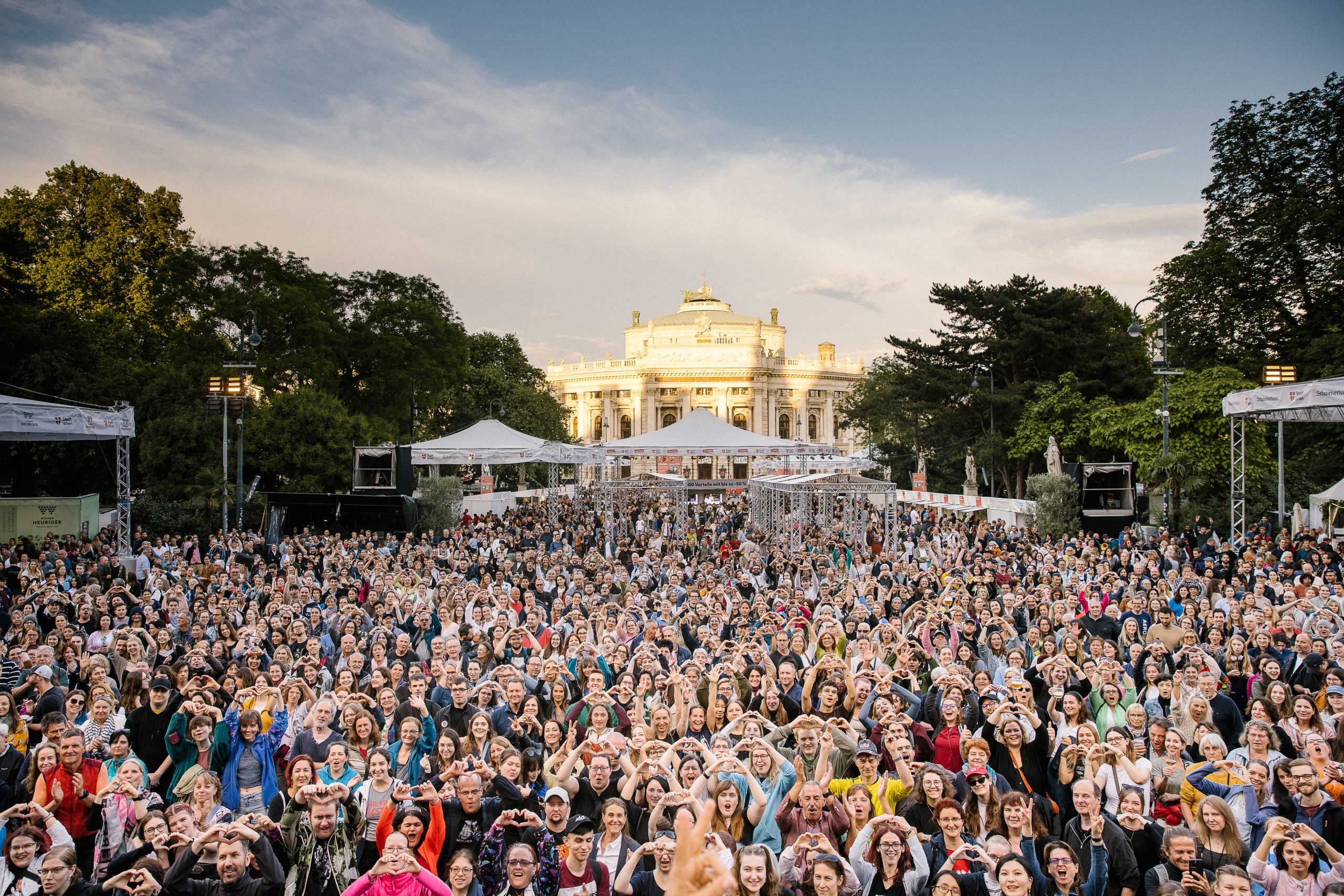 © stadt wien marketing / Studio Wey Blick auf eine große Menschenmenge von einer Bühne aus. Im Hintergrund ist das Burgtheater.