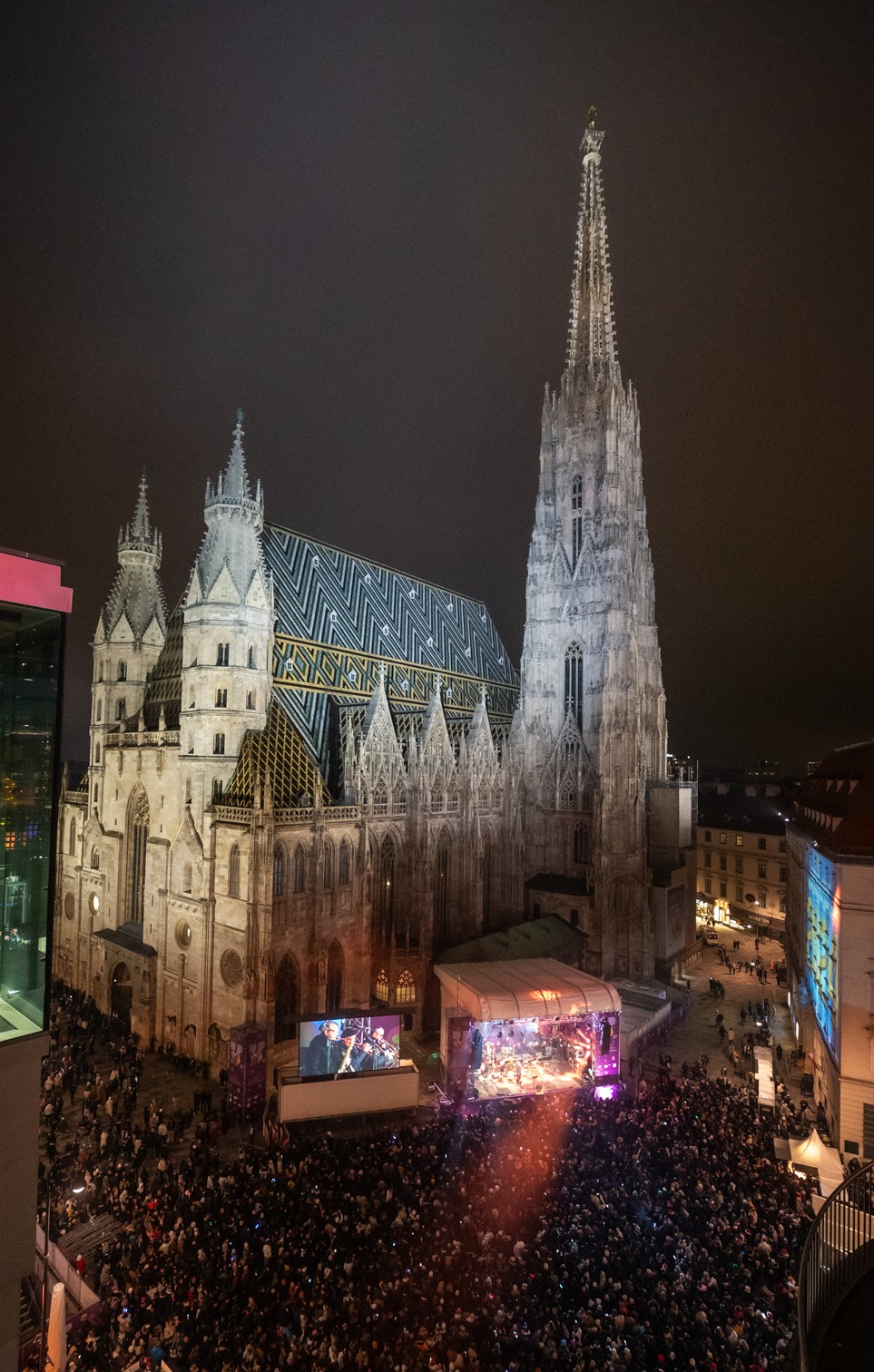 Sicht auf den Wiener Stephansdom bei Nacht mit einer großen Bühne und Menschenmenge beim Wiener Silvesterpfad.