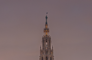 Teil eines aufgesplitteten Fotos des Rathaus. Auf diesem ist die Turmspitze mit dem Rathausmann zu sehen. Der Himmel ist rosa gefärbt.