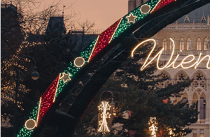 Teil eines aufgesplitteten Fotos des Rathaus. Auf diesem ist das Dach des Rathaus zu sehen und ein Teil des Bogens. Der Himmel ist rosa gefärbt.