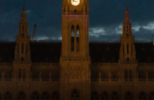 Teil eines aufgesplitteten Fotos des Rathaus. Auf diesem ist der untere Teil des Turms sowie das Dach zu sehen.