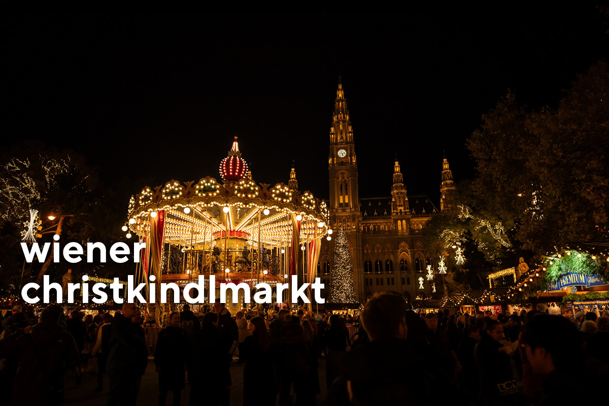 Wiener Rathaus mit beleuchtetem Karussell zur Weihnachtszeit.