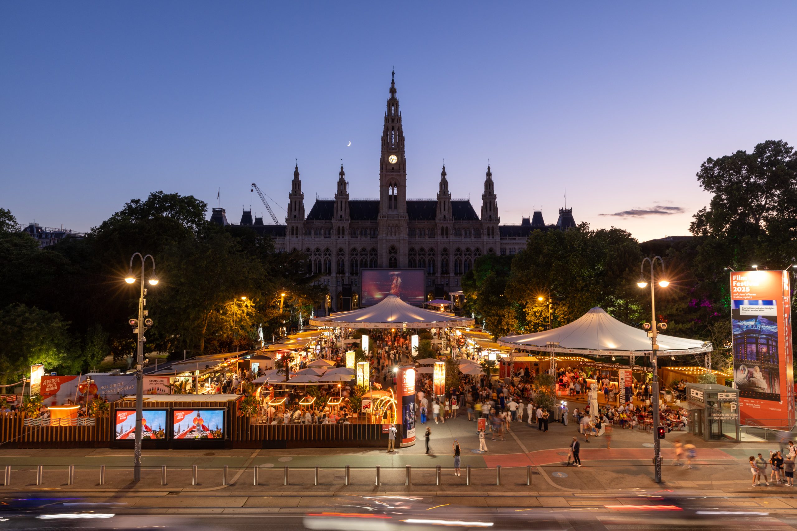 © stadt wien marketing / Georg Krewenka Frontal Ansicht auf das Rathaus und den Rathausplatz während des Film Festivals bei Dämmerung.