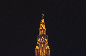 Teil eines aufgesplitteten Fotos des Rathaus. Auf diesem ist die Turmspitze mit dem Rathausmann zu sehen. Das Rathaus ist beleuchtet.