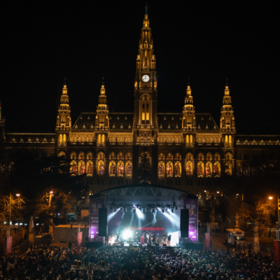 Silvesterpfad Der Wiener Silvesterpfad am Rathausplatz. Zahlreiche Menschen feiern auf dem festlich beleuchteten Platz. Im Mittelpunkt befindet sich eine Bühne, während das Wiener Rathaus im Hintergrund zu sehen ist.